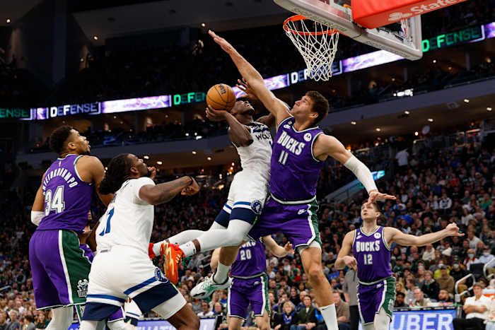 Anthony Edwards shoots a layup defended tightly by Brook Lopez